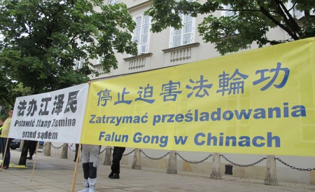 波兰法轮功学员在华沙总统府外面手持条幅,和平请愿。(黄诃欧/大纪元)